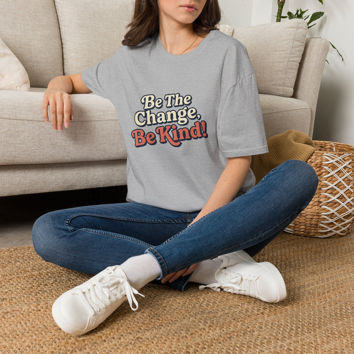 Be the Change Be Kind T-Shirt - Kindcore ComfortsWoman sitting beside a couch wearing a light-blue T-shirt with “Be the Change, Be Kind!” printed on the front.ST-ShirtPrintifyKindcore Comforts96235453922190564902